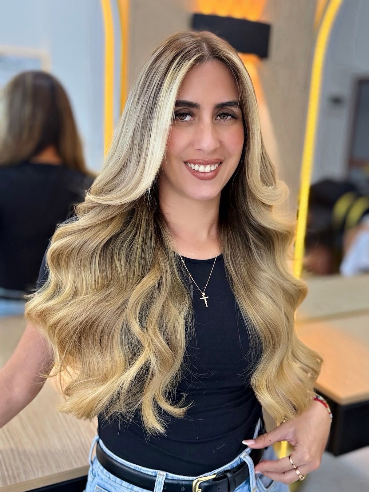 Clienta sonriendo con balayage rubio de ondas suaves